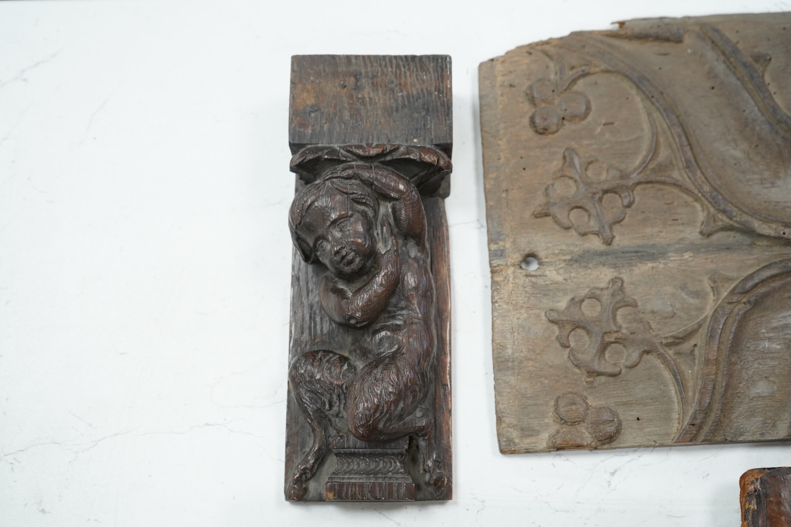 A 19th century leather binding for a book, 35cm high x 33.5cm wide, two carved gothic panels and a carved figure
